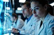© starush - Scientists analyzing data on digital screens in a high-tech laboratory environment