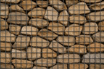 Poster - Metal mesh covering a stone wall