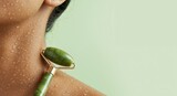 Close-up of a person using a jade roller for skincare.