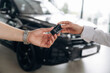© standret - Purchase is successful. Detailed view of hands of customer that is taking keys for new purchased car