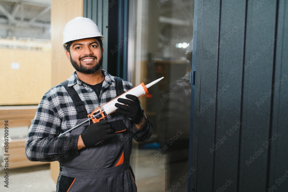Indian worker is applying polyurethane foam to fill gap between sash ...