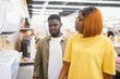 © Serhii - An African American man and woman choose an air conditioner in an electronics store