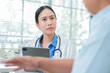 © whyframeshot - Asian female doctor conducts thorough medical consultation with elderly Caucasian patient, actively listening to mental and physical health concerns. Professional physician takes detailed notes