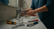 © Liam - Handyman repairing a dripping bathroom sink faucet with professional tools. Home maintenance and plumbing service.