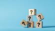 © Sutasinee - question mark icon on wooden cubes on a blue background,  Q and A, questions and answers concept.