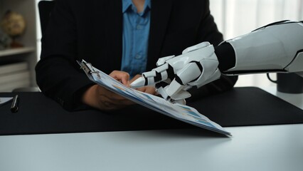 Poster - A robotic hand meticulously assists a human in an office setting, holding a clipboard filled with various colorful charts and graphs, symbolizing collaboration and innovation.Noogenesis