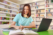 © New Africa - Student with laptop studying at table in library