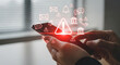 © Pixel Studio - A person holds a smartphone displaying a glowing red warning icon with various notification and communication symbols