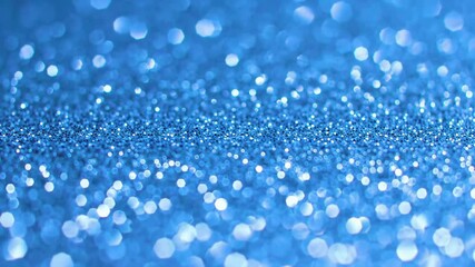 Blue glitter background with bokeh effect and shallow depth of field