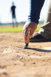 © Wavebreak Media - Male maintenance worker brushing dirt from home plate with brush on baseball diamond under sunlight