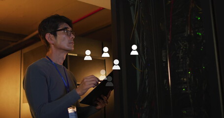 Poster - Korean technician checking server rack in server room, holding tablet and wearing lanyard