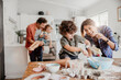 © Marko Geber - Young caucasian family being messy and having fun baking together in the kitchen