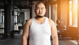 ジムでカメラ目線の太ったアジア人男性インストラクター