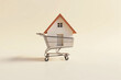 © Jelly - miniature house placed inside a shopping cart on a clean neutral background symbolizing property investment, home buying, mortgage planning, and financial real estate decision making