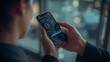© imran - Person holding a smartphone displaying a financial dashboard with charts and graphs in a modern office setting