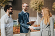 © qunica.com - A professional meeting outdoors between colleagues as they discuss business opportunities and agreements.