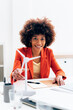 © Westend61 - Happy businesswoman with windmill model sitting at desk in office