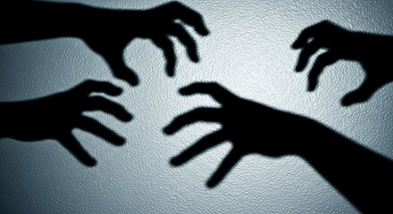 Poster - Four dark hand shadows projected on a textured light-blue surface, creating a mysterious and suspenseful atmosphere, symbolic of fear, threat, or unseen presence