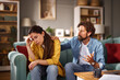 © Stockphotodirectors - A couple talks in their cozy living room, visibly stressed as one partner comforts the other. They are discussing serious financial issues that are affecting their relationship.