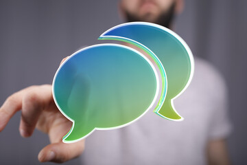 Leinwandbilder - Abstract image of a hand holding digital speech bubbles, representing communication and conversation.