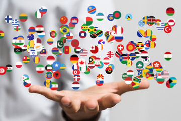 Poster - Image of many national flags floating above a hand, representing global connections and international relations.