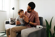 © kleberpicui - Father helping young son with nebulizer treatment at home
