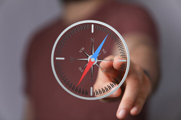 Poster - Hand pointing at a digital compass screen, indicating direction and guidance. Ideal for navigation, travel, or strategy concepts.