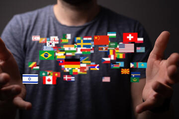 Poster - A man's hands reach out towards a digital display of many world flags, symbolizing international connections.