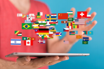 Poster - Person using tablet displaying flags of various countries.  International communication concept.