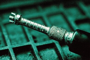 Poster - Close-up of a precision screwdriver on a textured surface in a workshop setting