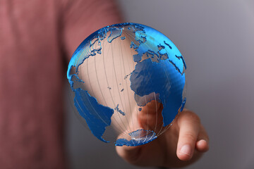 Poster - Hand holding a digital earth globe, showcasing global network and connection.