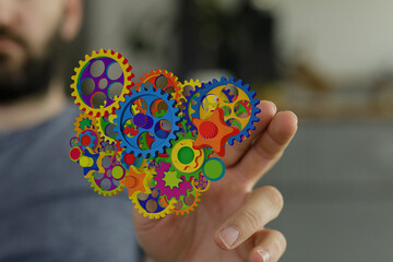 Poster - Image of colorful gears in a hand, representing teamwork, collaboration, and innovation.