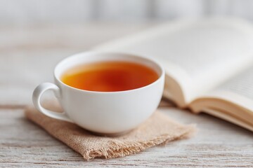 Poster - cup of tea open book and glasses on rustic wooden table