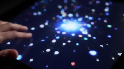Poster - Hand Interacting with Cluster of Blue And White Bokeh Lights on a Black Display Screen with a Bright Focal Point
