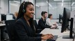 © MstShilpi12 - Smiling black woman with braids wearing a headset works at a computer in a modern office setting