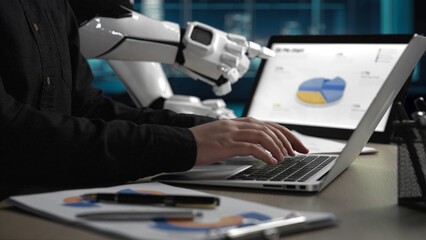 Poster - A modern workspace showcasing a human interacting with a laptop while a robot assistant displays data analytics, emphasizing the fusion of technology and business processes.Noogenesis
