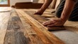 © Riko - Caucasian adult male installing rustic wooden flooring in home renovation project
