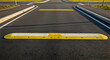 © TITI - Yellow Speed Bumps On Asphalt Road Prevent High Speed Driving Safety Concept