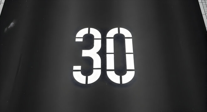 White Number Thirty Stencil on Black Surface for Industrial Marking and Labeling