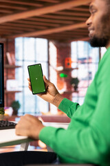 Poster - Happy man at home using green screen phone to browse social media website, looking at memes. Jolly person in apartment looking at funny content online on chroma key smartphone