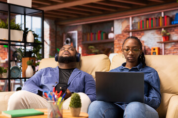 Poster - Smiling female freelancer browsing the web on her laptop in a modern living room, demonstrating a lifestyle of independence and productivity in a virtual workspace. Woman multitasking.