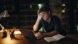 © stockbusters - Overworked manager planning budget looking laptop at night workplace closeup.