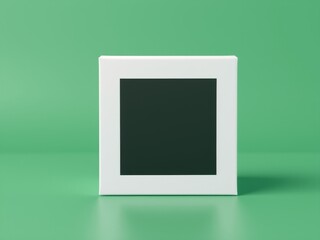 Poster - White frame with a black square inside sitting on a green surface in a minimalist style studio shot