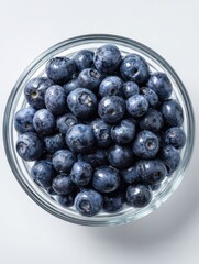 Poster - Fresh Blueberries in a Glass Bowl on a White Background Create a Clean and Minimal Still Life Display for Culinary Enjoyment