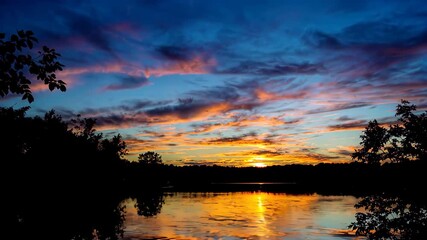Wall Mural - arafed view of a lake with a sunset reflecting in the water