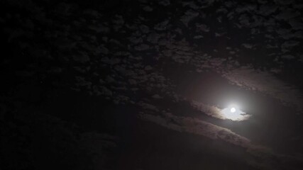 Wall Mural - timelapse. night sky. moonlight between fast-moving clouds. moon and stars between cloud clusters mo