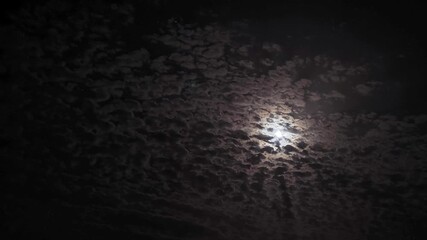 Wall Mural - timelapse. night sky. moonlight between fast-moving clouds. moon and stars between cloud clusters mo