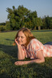 © Cavan - Middle age woman laying down on the grass, summer time