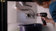 © Video_StockOrg - Plumber drill through clogged sink pipes with spring tube tool