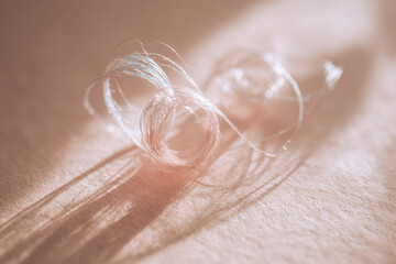 Aufkleber - Delicate white thread tangled gently on clean paper, soft light and subtle shadow create calm, minimal, and artistic atmosphere, evoking sense of tranquility